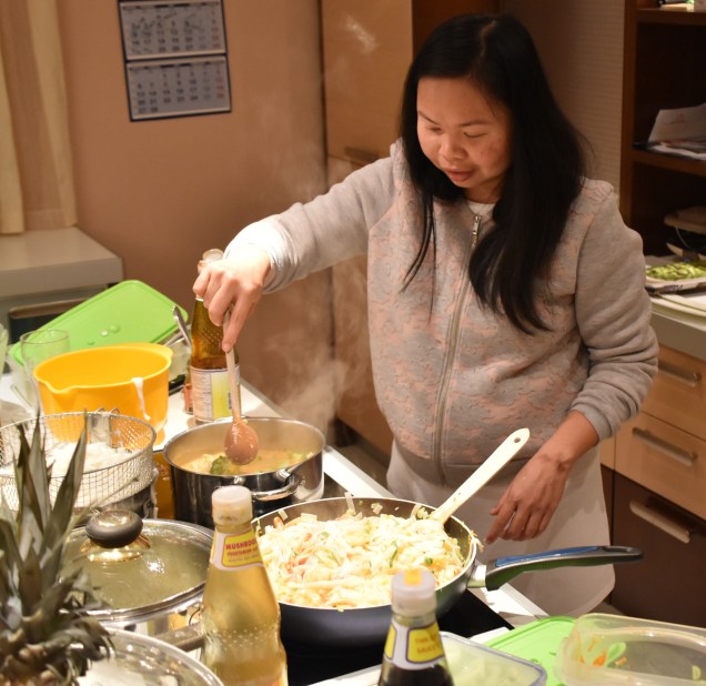 Jaj kuha riževe rezance s škampi, s pikantno zelenjavo in sesekljanimi slanimi arašidi, ki so zelo po slovenskem okusu